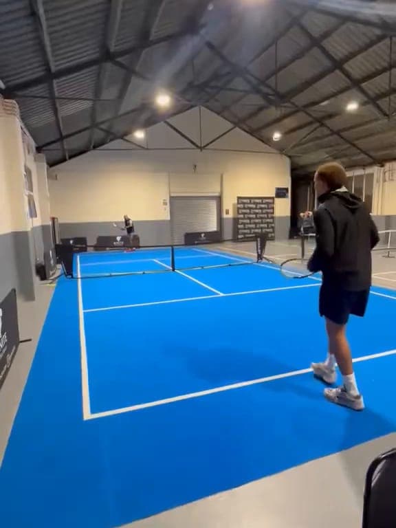The blue court seen from the baseline as a player gets ready to serve